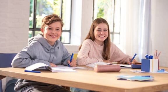 2 Mädchen sitzen am Schreibtisch